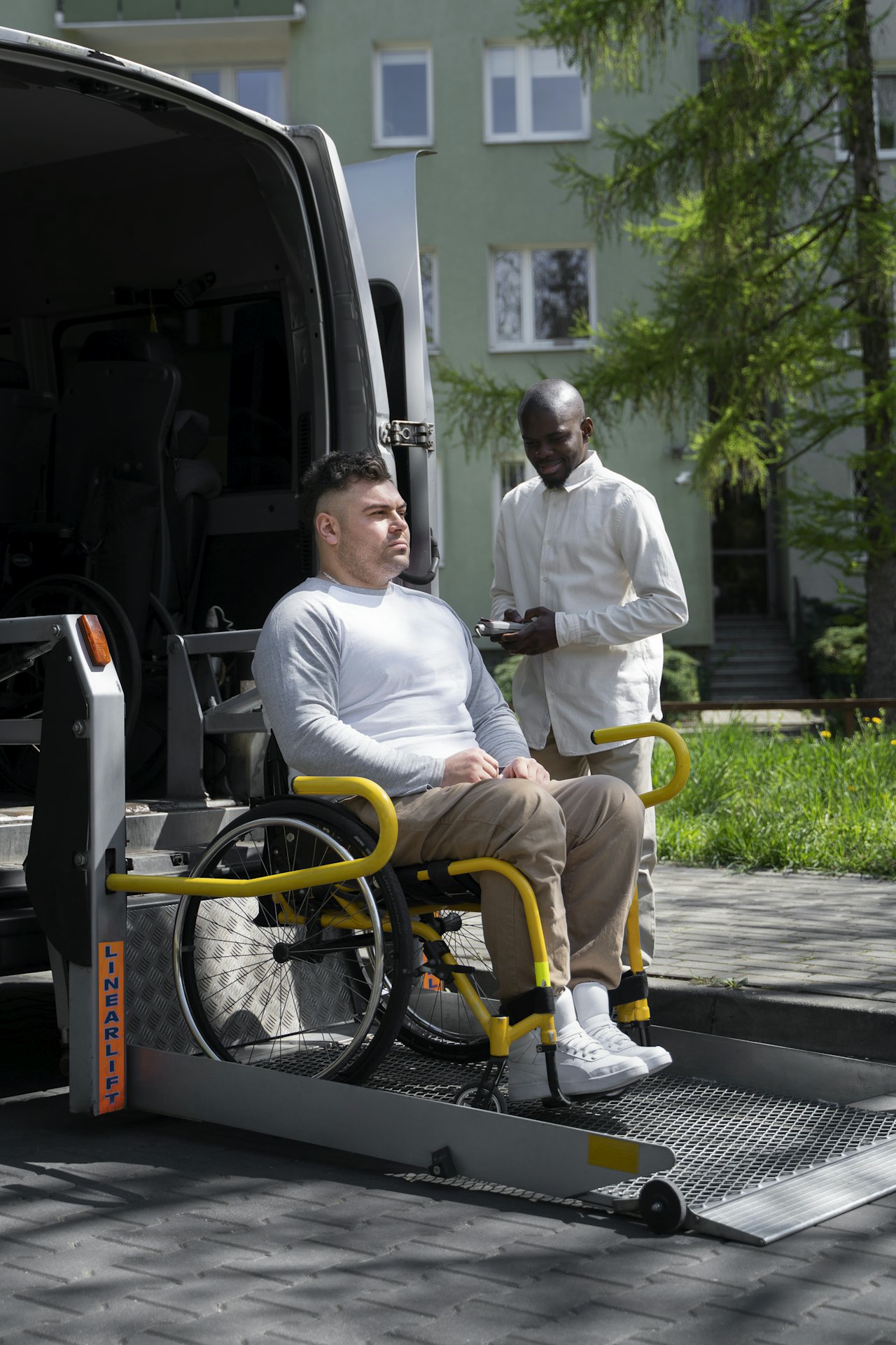 Star Med Couriers passenger in a wheelchair with driver assistance at a wheelchair-accessible van